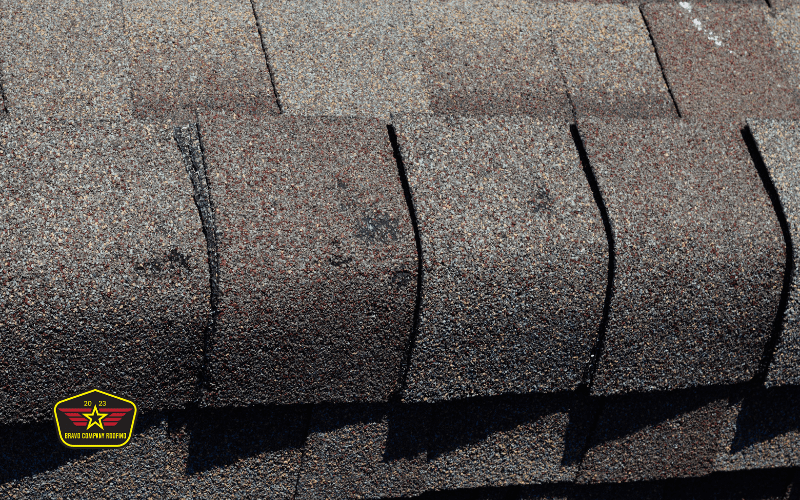 Bravo Company Roofing Close-up view of asphalt roof shingles with a small badge displaying "2023 Roof Claim Nation" in the lower left corner.